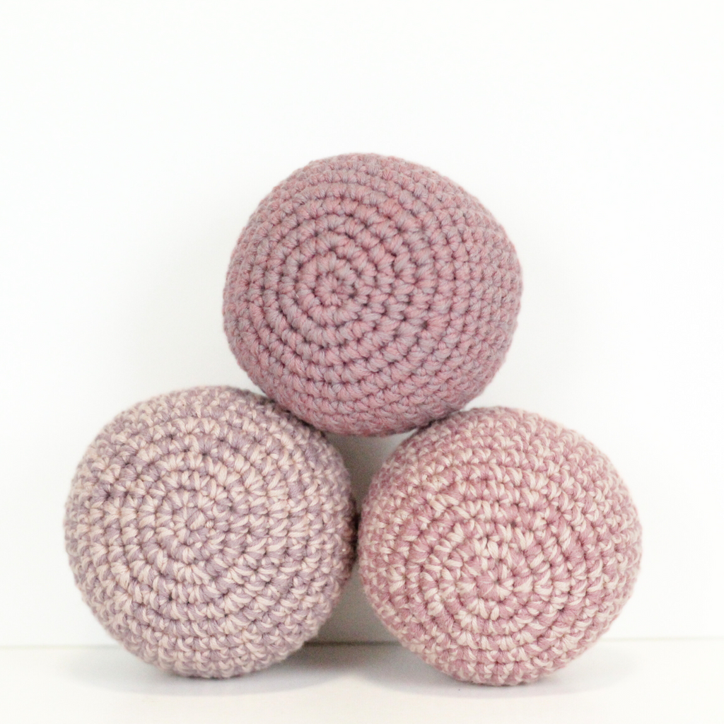 Three pink crochet balls stacked. Handmade crochet dog toys from Lana Royals Pet Wear.