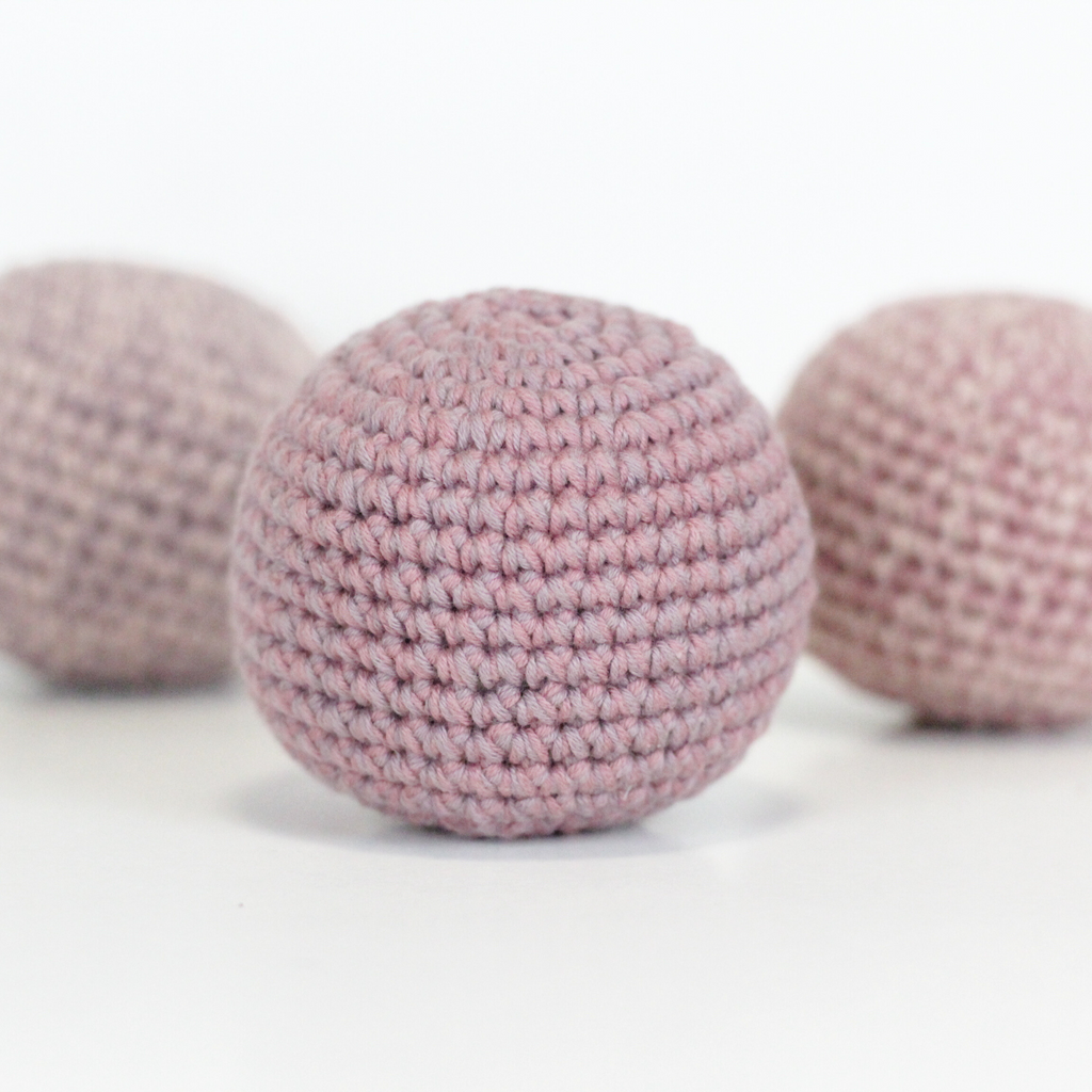 Three pink crocheted balls. Handmade crochet dog toys from Lana Royals Pet Wear.