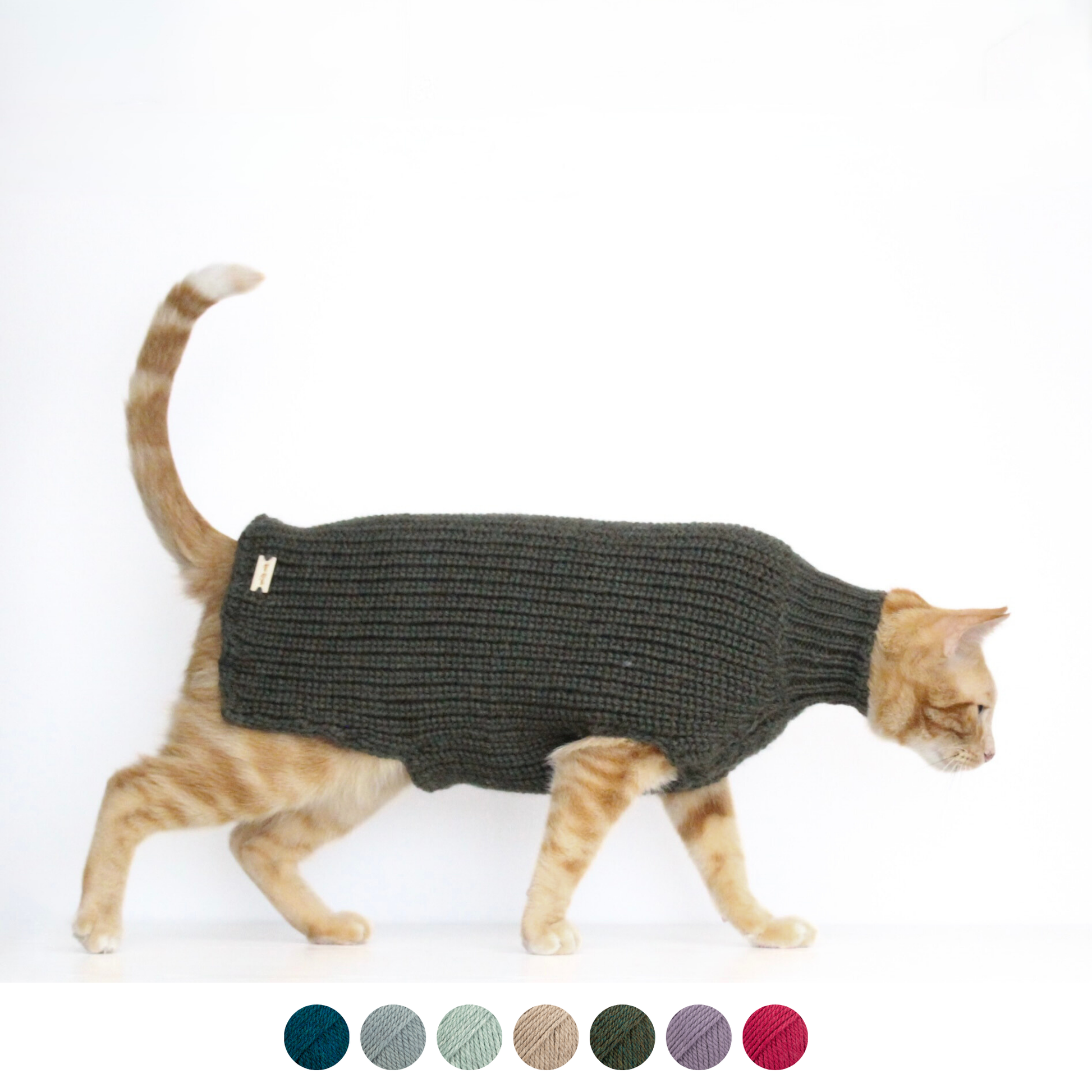 Ginger cat wearing a hand-knitted alpaca wool sweater in dark green color sweater, custom-tailored to measure by Lana Royals Pet Wear.