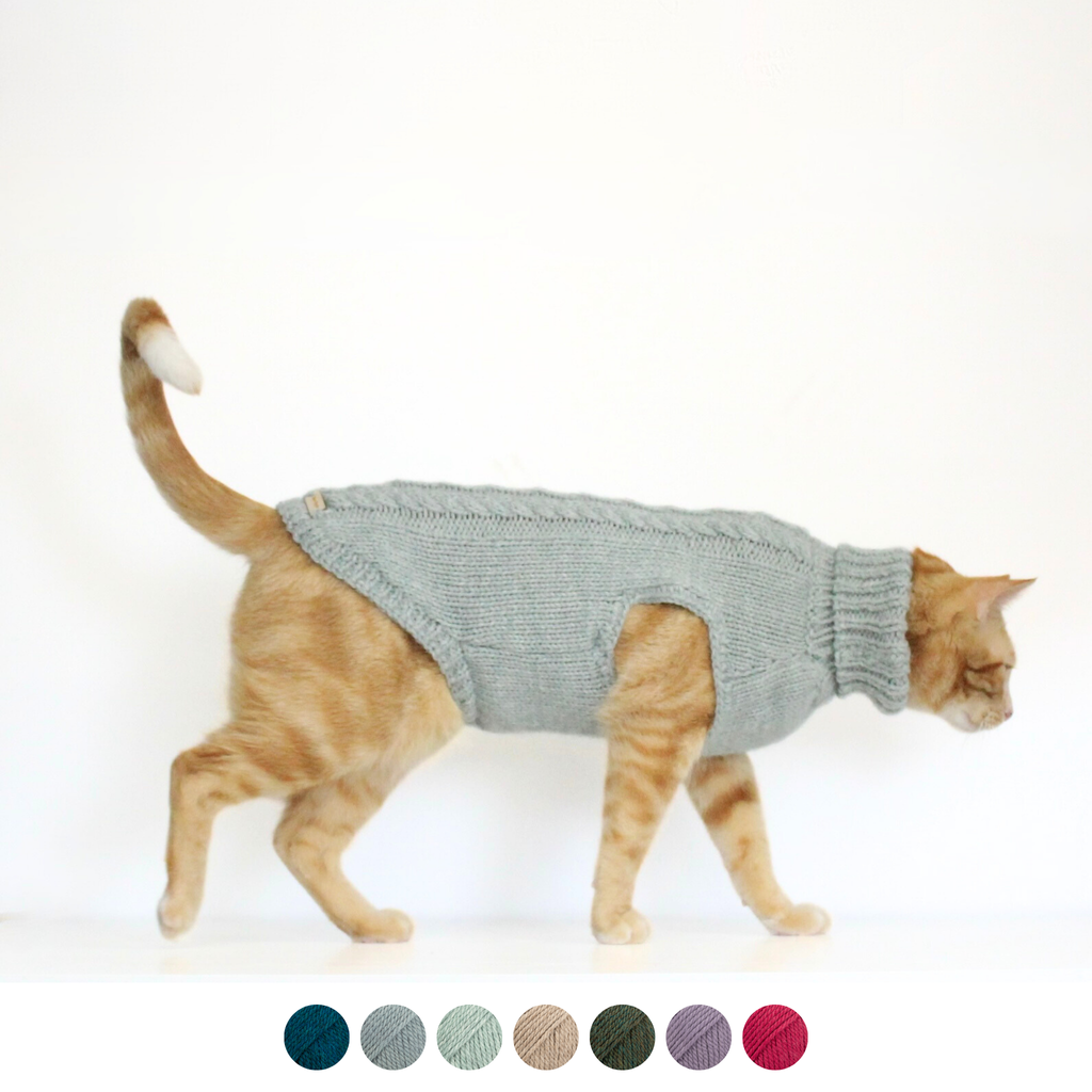 Ginger cat wearing hand-knitted alpaca wool turtleneck sweater in soft mint color, custom-tailored to measure by Lana Royals Pet Wear.